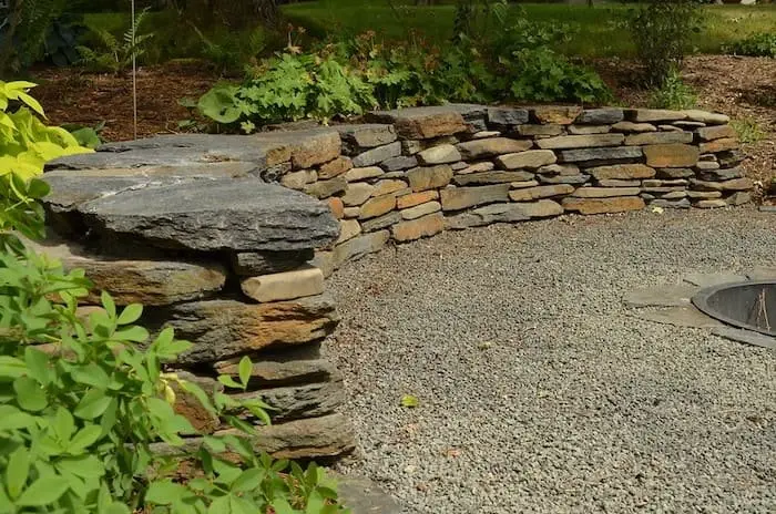 Heavy quarry boulder retaining wall along property grade